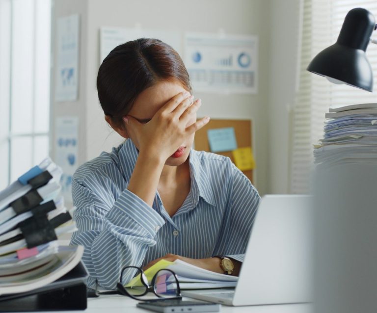 Fachlicher Vostand sozialer Verband überfordert. Person sitzt am Schreibtisch und ist sichtbar erschöpft.